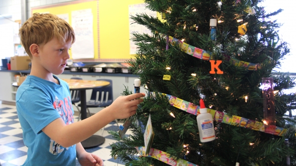Joel Neufeld helps decorate a class tree at Boissevain School. The entire student body will be involved in decorating 20 trees, donated by Boundary Co-op for auction at a Chamber event on Thursday, December 5. This is a new addition to the annual Chamber Christmas festivities. Money from the auction will go to the school as well as the assisted living project. 