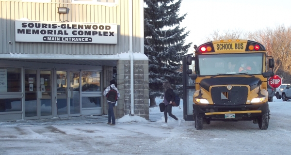 Students disembark a bus on a windy Wednesday morning, January 20 at the Souris Community Hall. Souris School grade 9 – 12 students began their new normal on January 18 as they returned to in-person classes. They had been remote learning since November, and now that the province has lifted that order, classes are back on a 50% basis at the Souris Community Hall. 