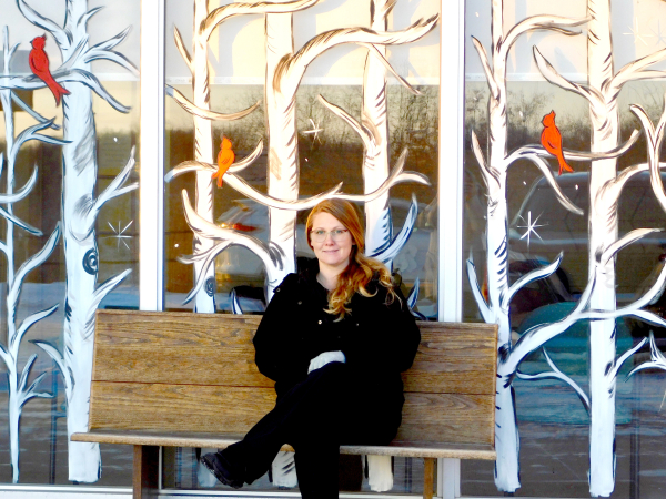 Michelle Wipf with the window art she created in the background. 