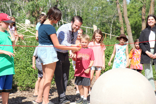 Andrea Linney watches proudly as Peace Garden CEO Tim Chapman gets the help of Liam Brown-Veselack and Madison Marion to cut the grand opening ribbon for the new nature playground at the International Peace Garden on July 30. This was part of the celebrations for the 90th anniversary of the Peace Garden. 