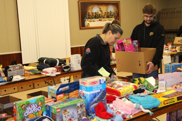 Michelle Buhler (left) and her son Randall fill a Christmas hamper with gifts for a special someone at the Christmas Cheer evening on Wednesday, December 18.  