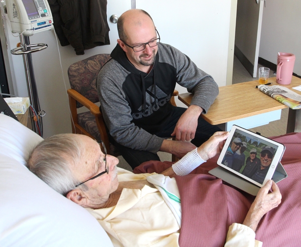Thanks to the newly installed WiFi, Boissevain Health Centre patient George Epp was able to look at photos from an e-mail on his iPad, with son Ernie Epp of Morden. 