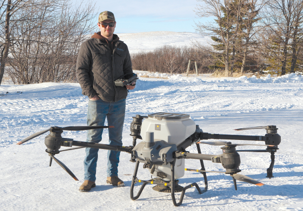 Jagger Thomas shows off one of two drones he and his father now use to do in-crop applications of cover crops. The machine measures eight feet wide and can carry between 50 and 110 lbs of seed. Crop mapping is done on a tablet-sized remote control with options to avoid obstacles and stop and start at will. 