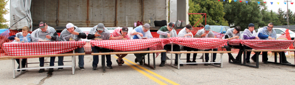 There was a lot of gobbling action at the pie eating contest at Street Fest. Twelve participants entered the contest for some free pie and a chance to win the $100 prize money and bragging rights. Allowed to only to use one hand (a fork was optional). Each contestant, draped in a clear garbage bag, raced as fast as they could to swallow down one of Alma Reimer’s famous apple pies. 