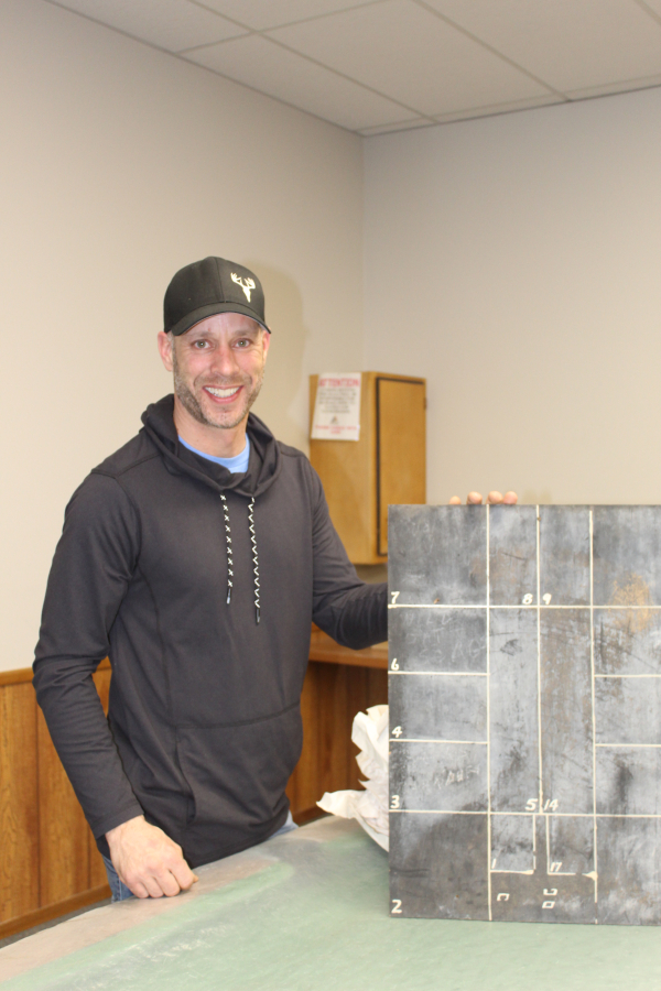 roy Angus of Pierson was able to salvage many treasures from the demolition of the Lake of the Woods elevator in Elva, Manitoba. He is holding up a bin board, used to keep track of what grain was stored in each bin. Angus’ business “The Den Authentic Barnwood” has been in operation for five years. He was one of the presenters at the Turtle Mountain Souris Plains Heritage Association’s ninth annual local history seminar on March 16.