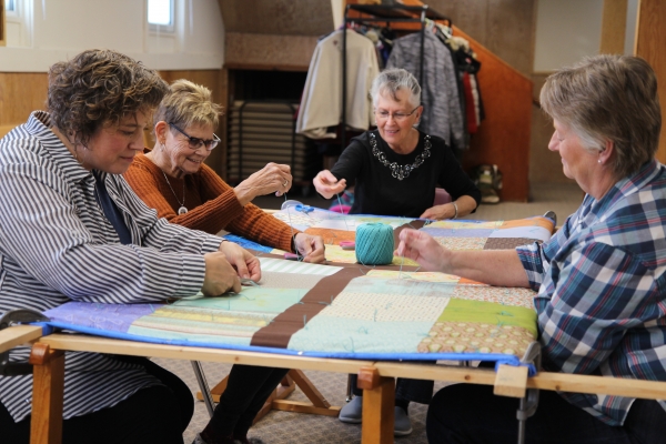   (L-R) Allison Martens, Emmy Martens, Bonnie Dancey and Anna Glover put the finishing touches on a comforter on Saturday, January 18. Willing and skilled volunteers gathered at the Whitewater Mennonite Church that day to participate in the Great Winter Warm-up, an event organized by Mennonite Central Committee to make comforters to help those in distress around the world. By the end of the month, they were hoping to have 6,500 warm coverings from across North America. The Boissevain crew chipped in 25. 
