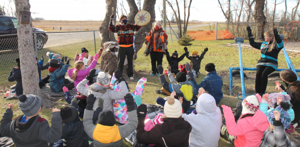 Winston Wuttunee and his wife Geri lead Minto School students in a prayer for the health of their tree. Wuttunee made a day long presentation at the school discussing Aboriginal culture, teaching songs and history on November 2. Despite a brisk wind, they were able to spend time outside for traditional prayer.